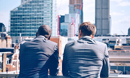Two men in suits against the backdrop of the city