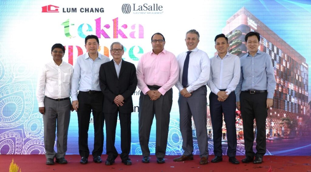 Men standing in front of the Tekka Place banner