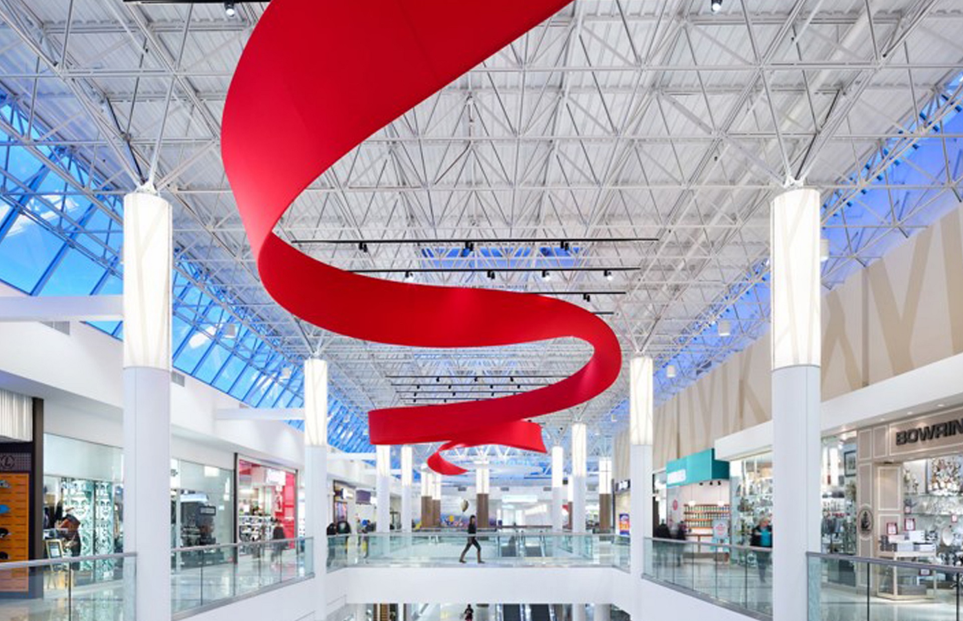 Installation resembling a red ribbon on the ceiling inside a shopping center