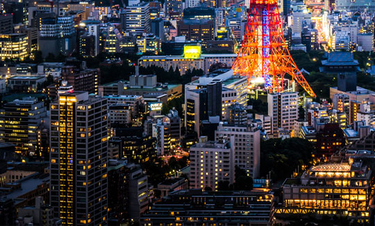 Illuminated city with tower at night