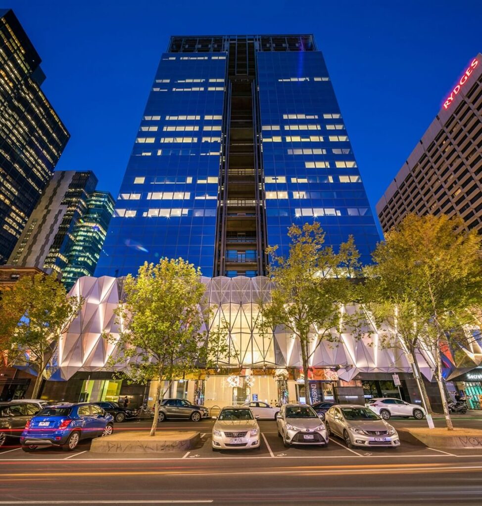 Cars in front of the illuminated entrance to a modern building