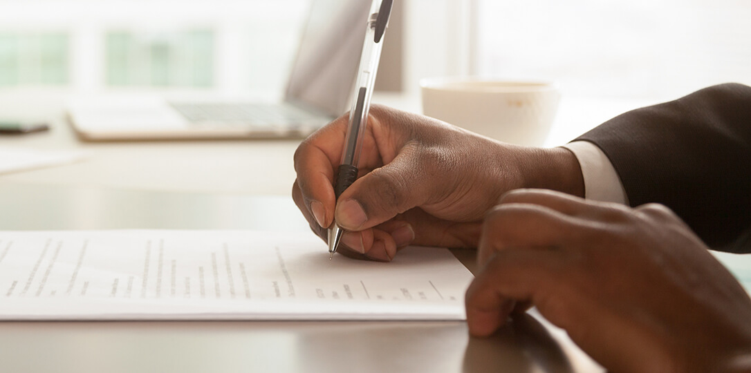 A photo of a hand signing a document