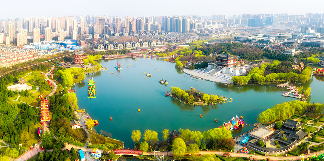 A park with a lake in the middle of the city