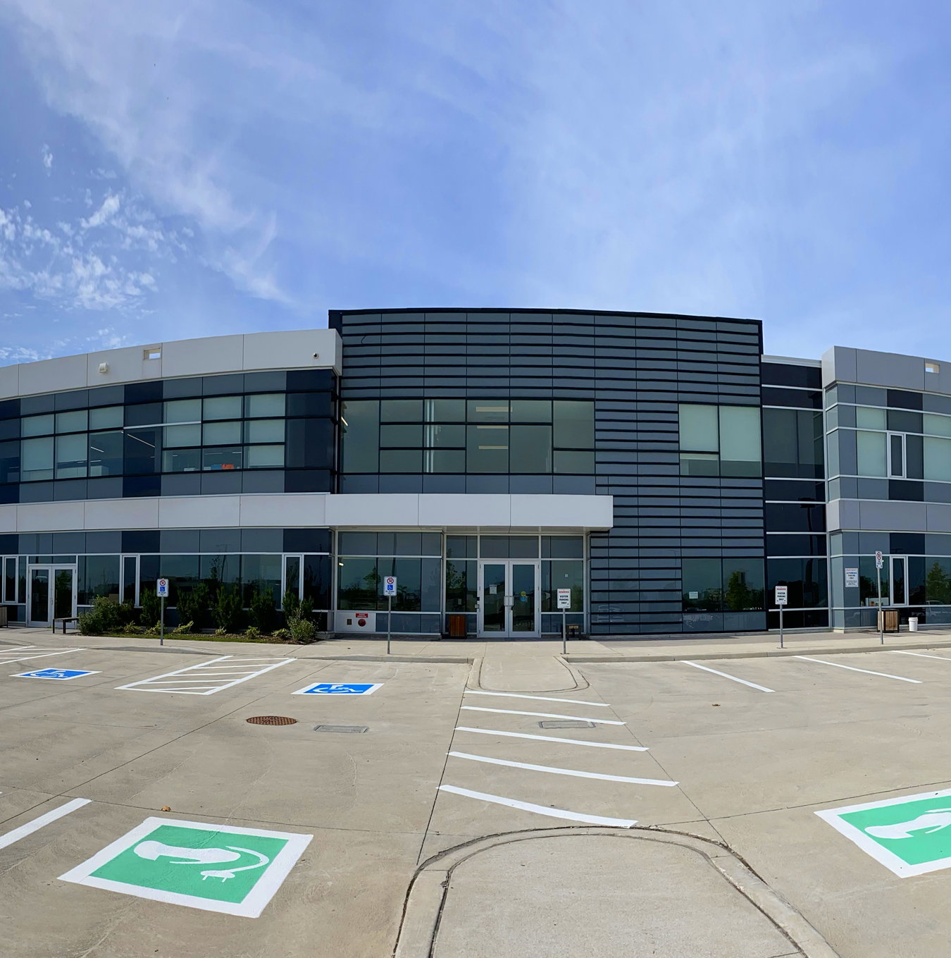 Modern, glazed building with parking