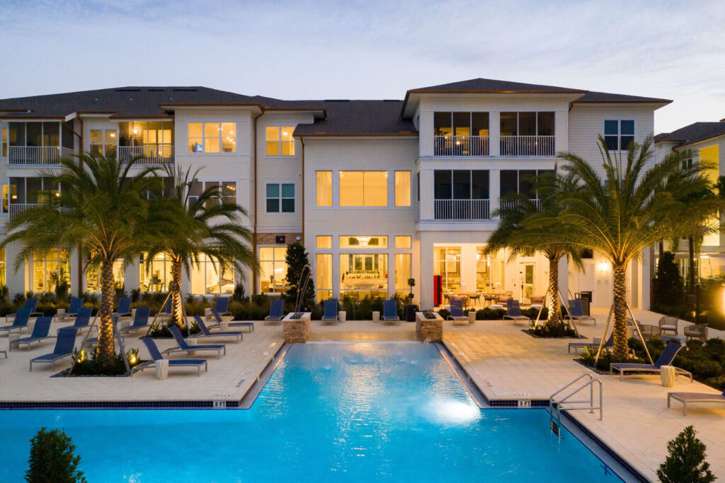 Illuminated hotel complex with swimming pool.
