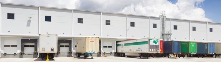 Truck trailers parked in front of a warehouse