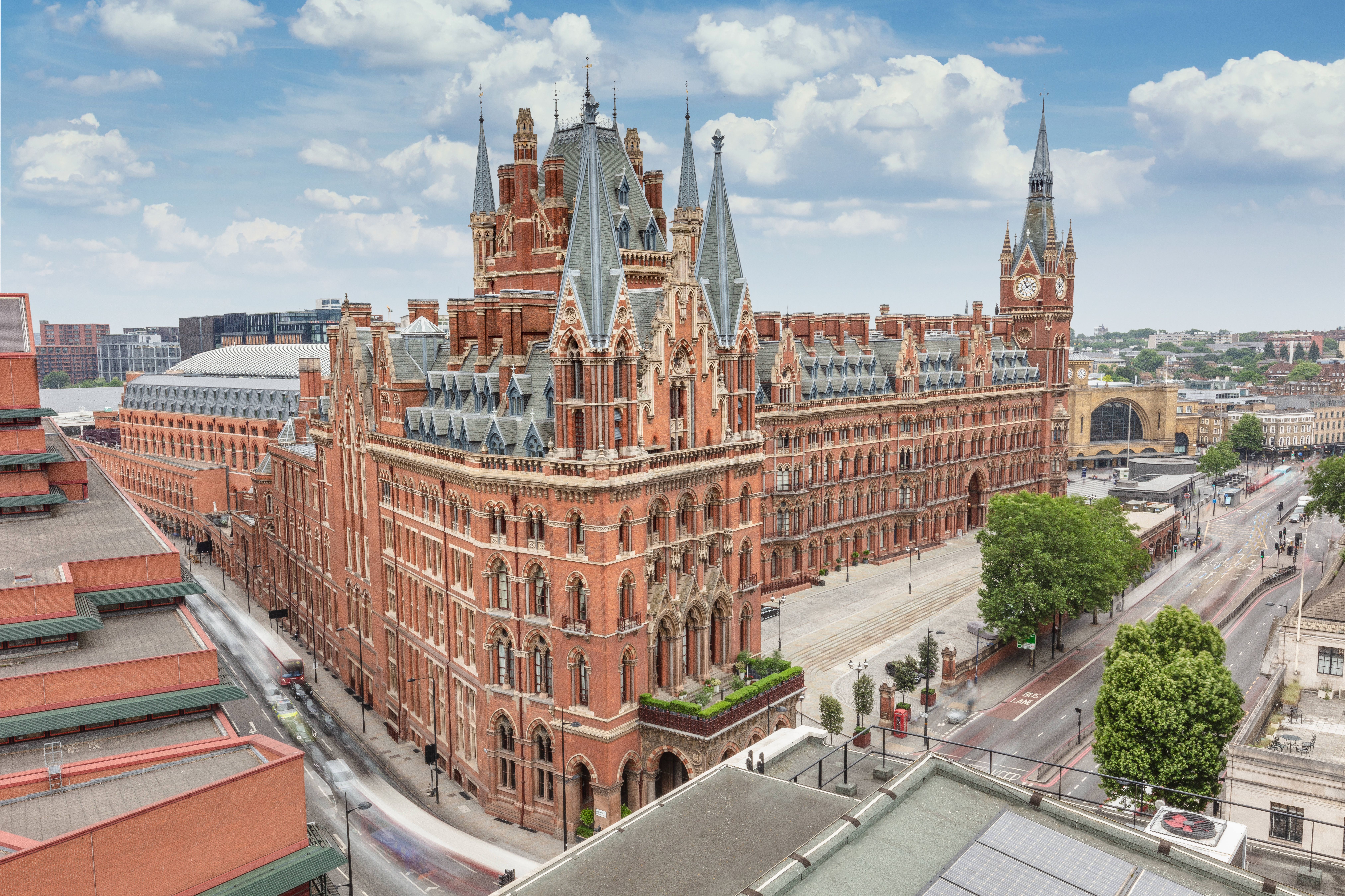 Exterior view of the historic St. Pancras Renaissance Hotel in London, highlighting its intricate Victorian Gothic architecture and characteristic red brick facade with spires and clock tower.